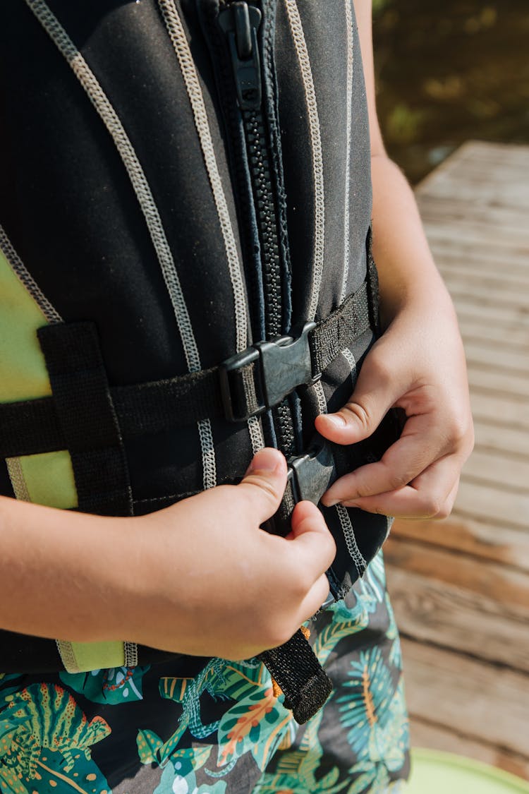 Close-up Of Boy Putting On Life Jacket