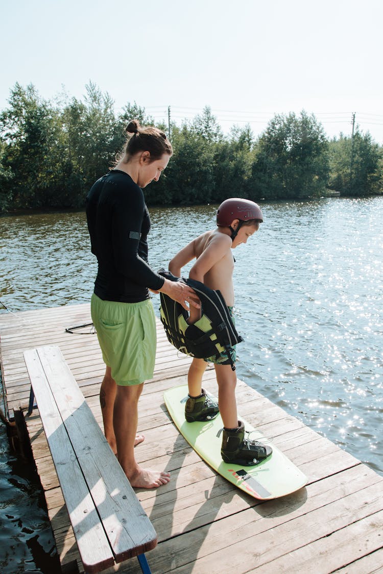 Boy Putting On Life Jacket Before Wakeboarding