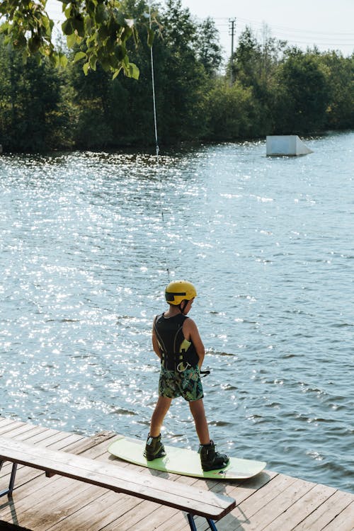 Boy Standing on Wakeboard on Jetty