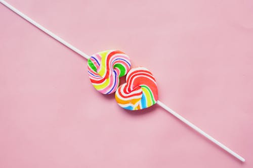 Heart Shaped Colorful Lollipops on Pink Surface