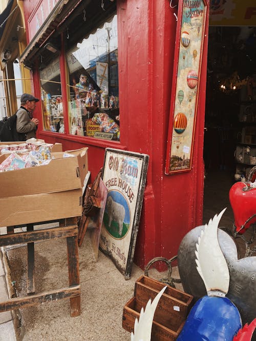 A Man Looking Through a Glass Window of an Antique Shop