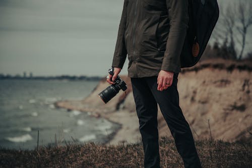 Standing Man in Jacket Holding Camera