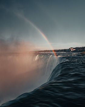 Breathtaking view of Niagara Falls with a vibrant rainbow and mist creating an awe-inspiring scene.