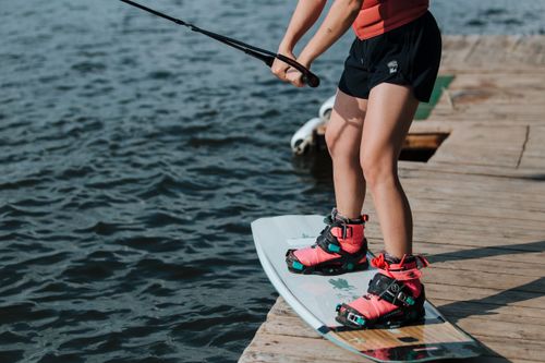 Free Close-up of a woman getting ready to wakeboard from a dock on a sunny day. Stock Photo