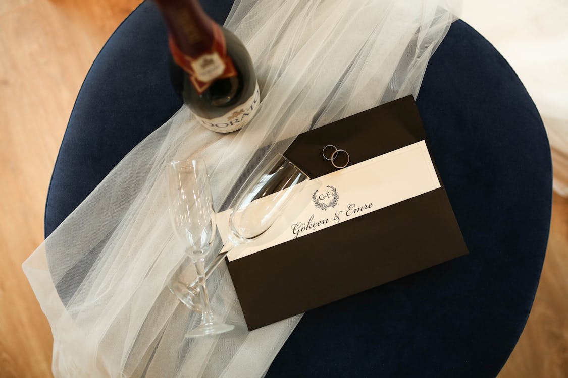 Champagne Glass and Wedding Invitation on a Black Table