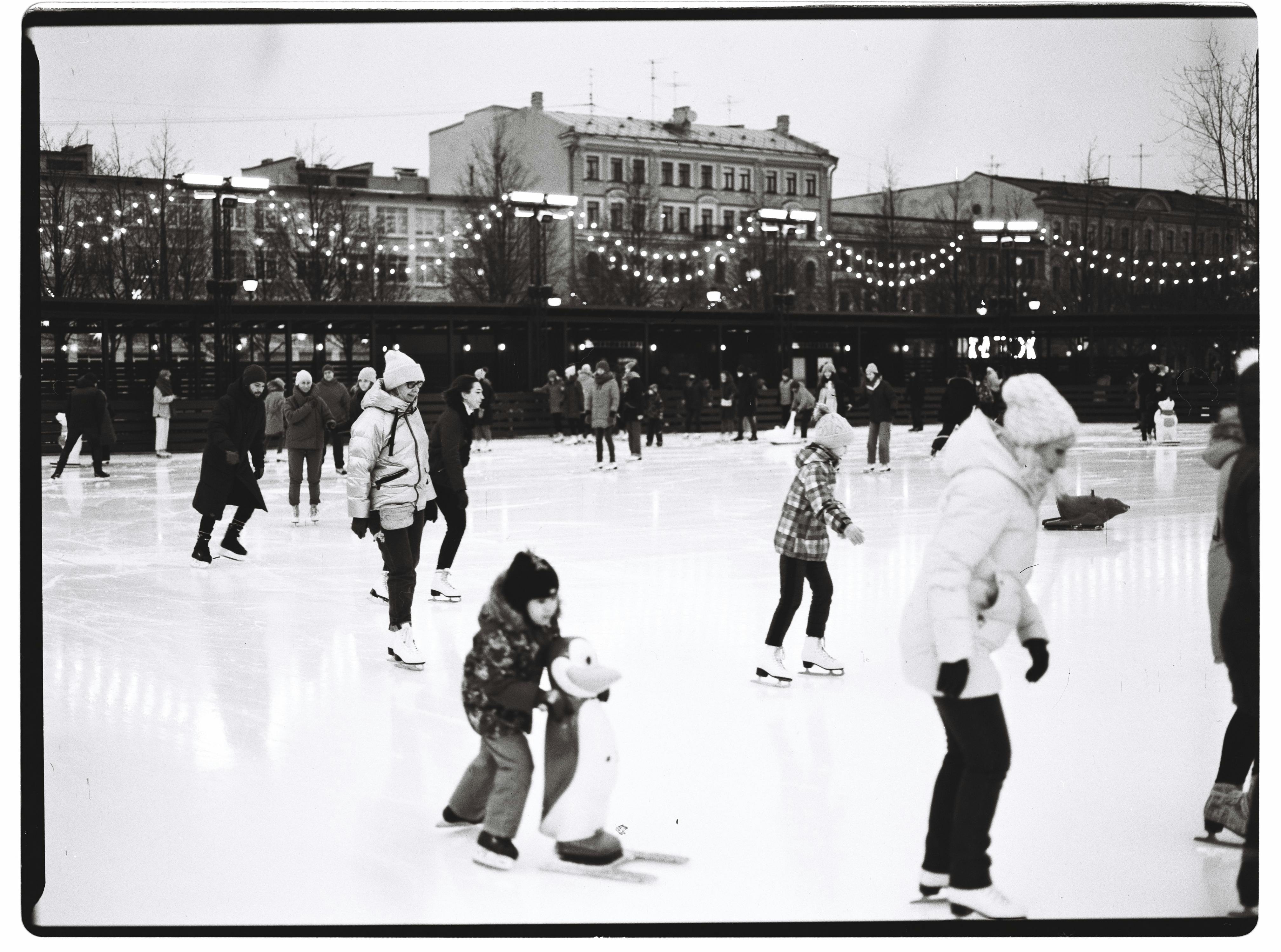 Black and white photo of people ice skating on a winter day in Saint Petersburg, Russia.
