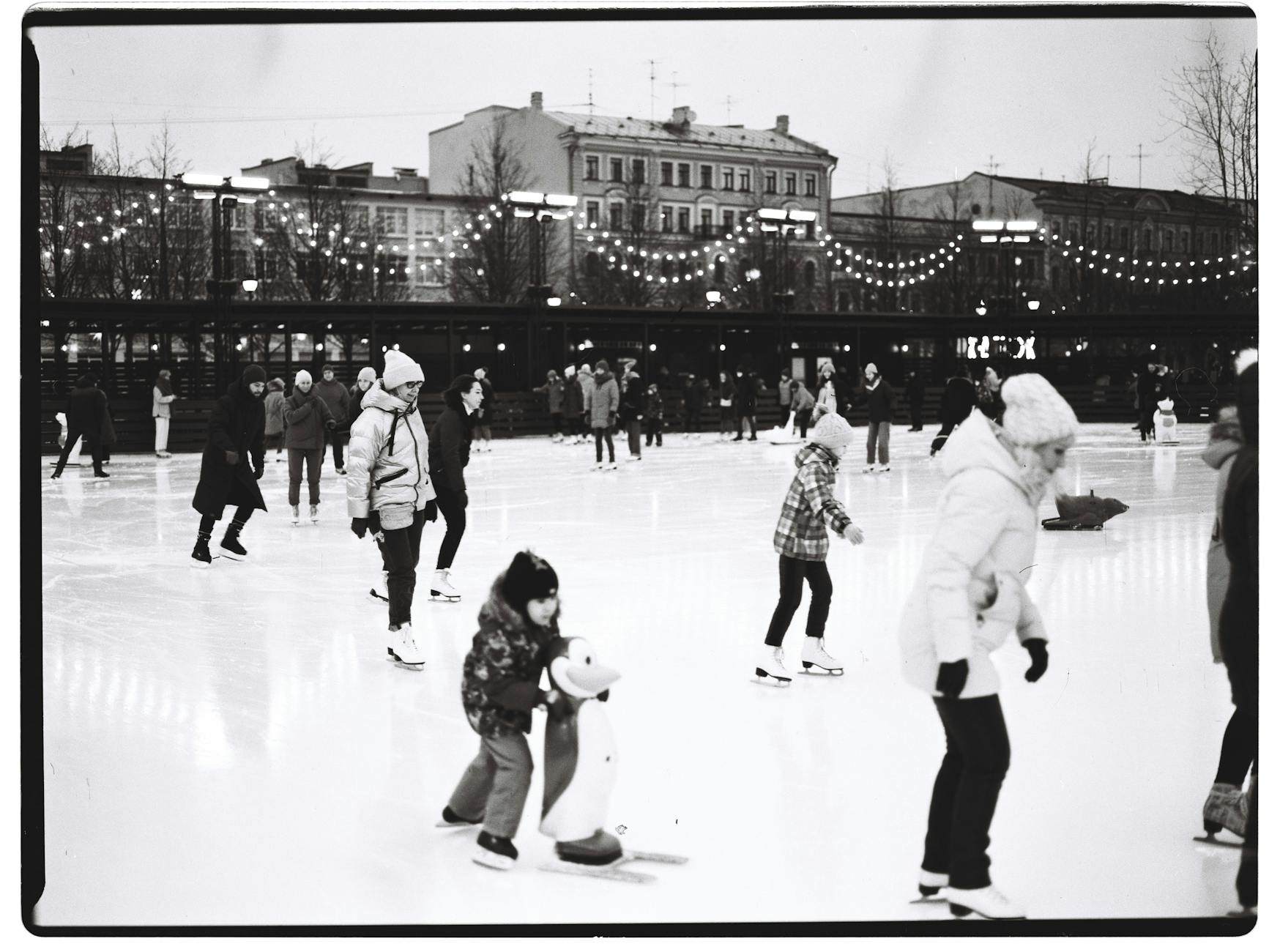 Black and white photo of people ice skating on a winter day in Saint Petersburg, Russia.
