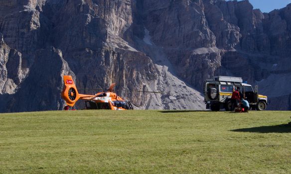 A rescue operation with a helicopter and SUV in the Dolomite mountains of Italy.