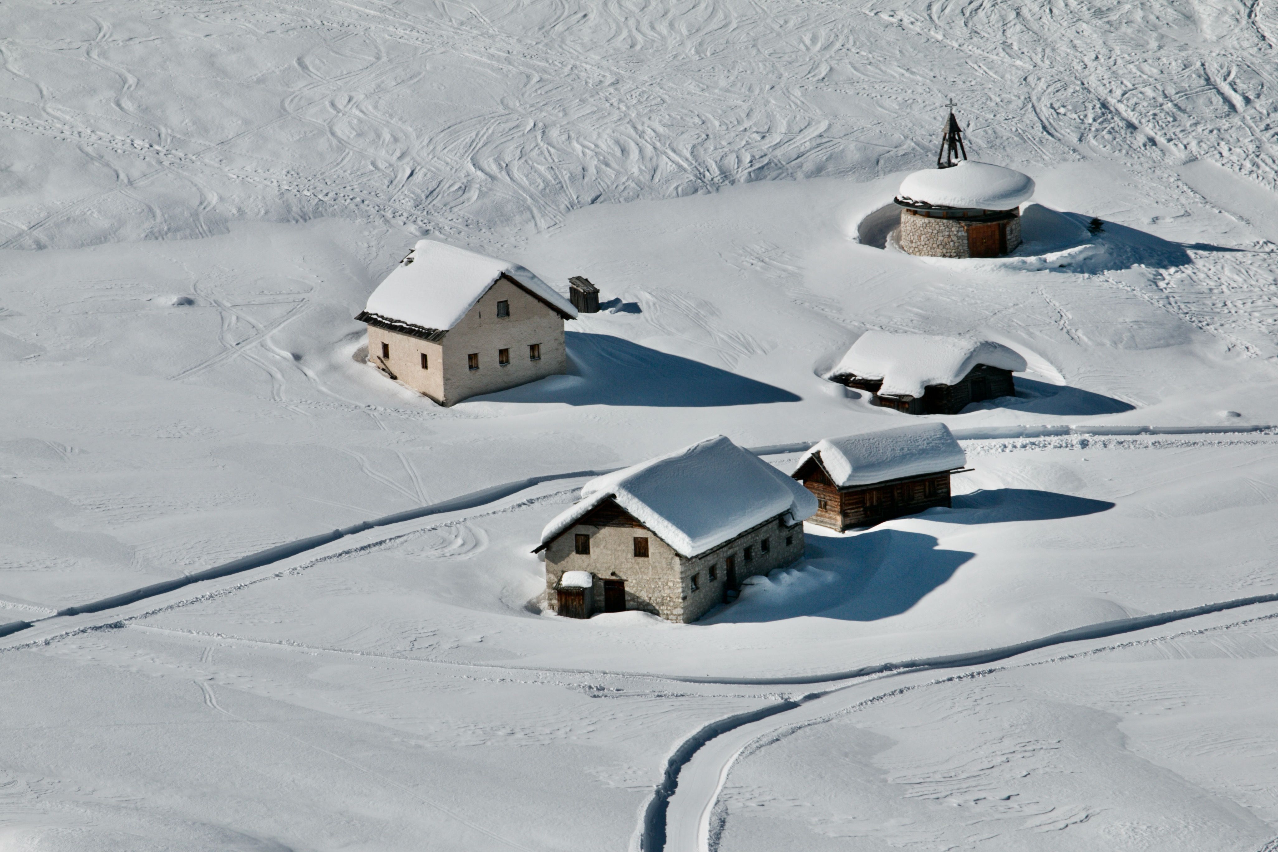 A cluster of snow-covered roofs beside a piste