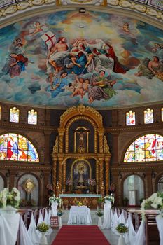 Stunning church interior featuring a vibrant fresco above a richly decorated altar.