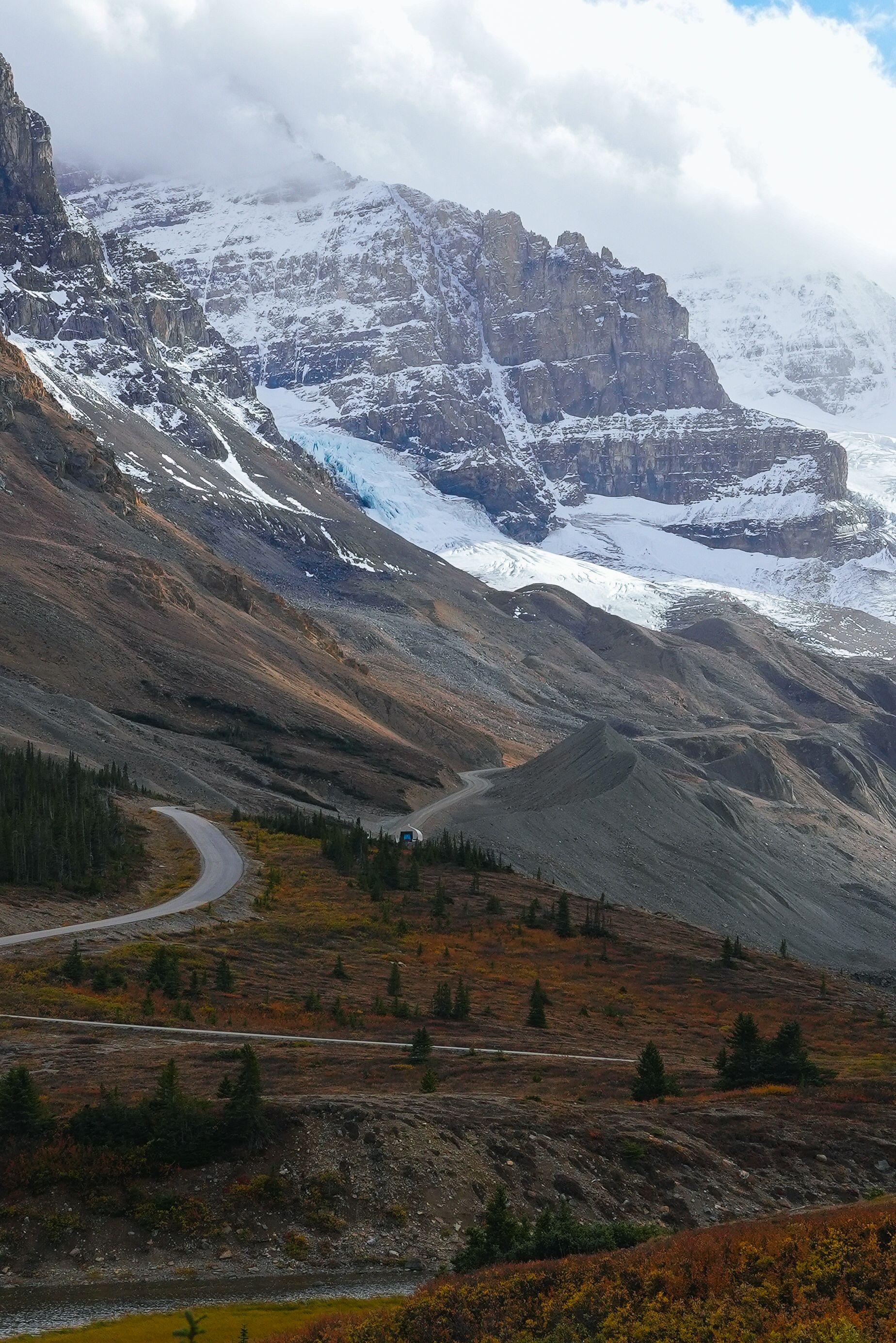 Breathtaking view of snow-capped mountains and winding road in the Canadian Rockies.