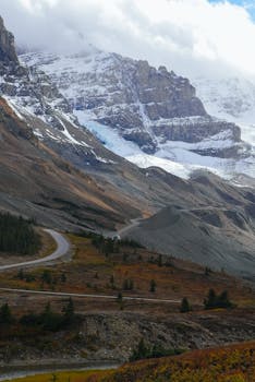 Breathtaking view of snow-capped mountains and winding road in the Canadian Rockies.