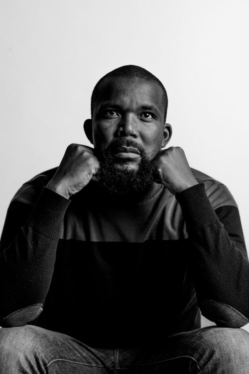 Free Black and white portrait of a contemplative man with beard and shaved head, indoors. Stock Photo