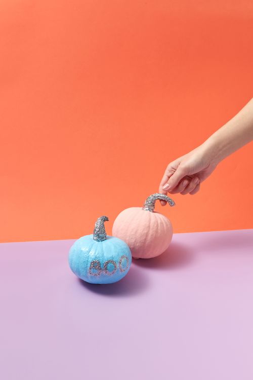 Free Playful pastel pumpkins with glittery stems on orange and purple backdrop, perfect for Halloween decoration. Stock Photo