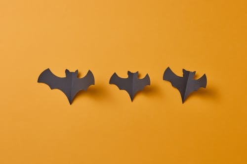Bat Shaped Paper Cut Outs on a Yellow Surface