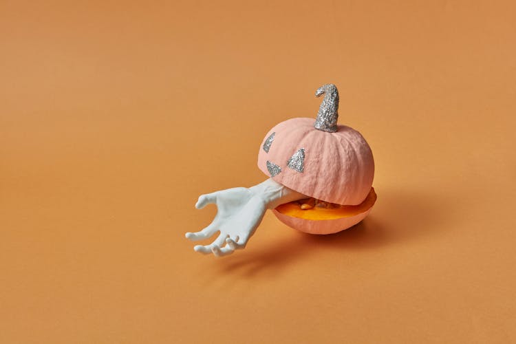 Mini Pumpkin With A Glittery Jack O Lantern Design With A White Fake Hand