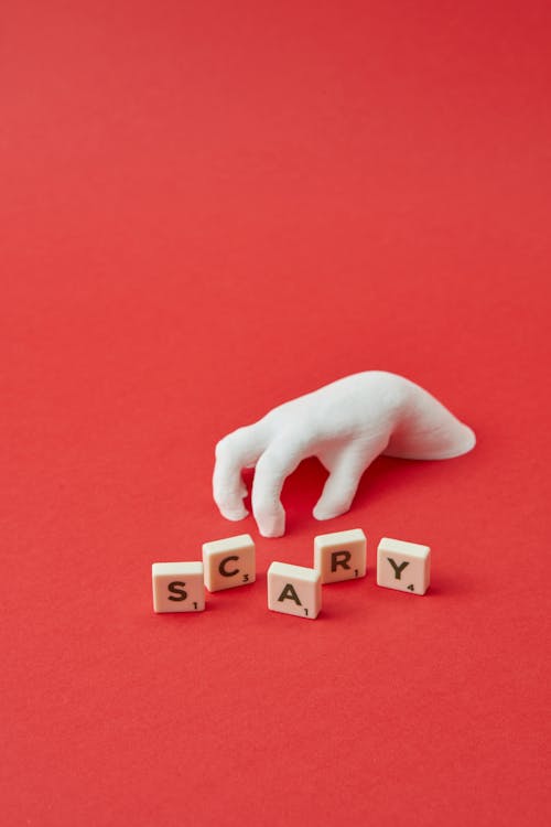 A Fake Hand and Scrabble Tiles with a Word Scary