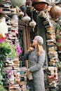 Woman in Beret Looking at Piles of Books Placed in Front of Antique Shop