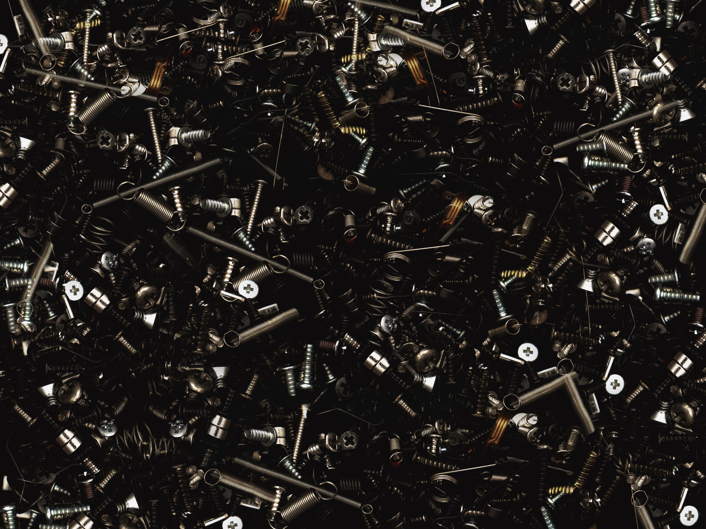 Close-up assortment of metal screws, bolts, nuts, and washers used for repair and assembly