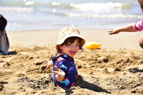A Boy in Blue Shirt Playing on the Beach