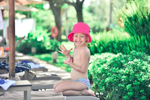 A Girl Wearing a Pink Hat Smiling