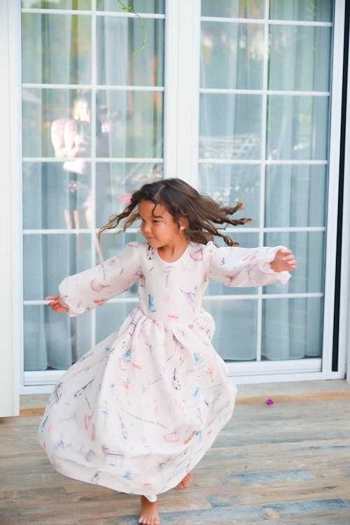 Girl in Long Sleeves Dress Standing Near Glass Window