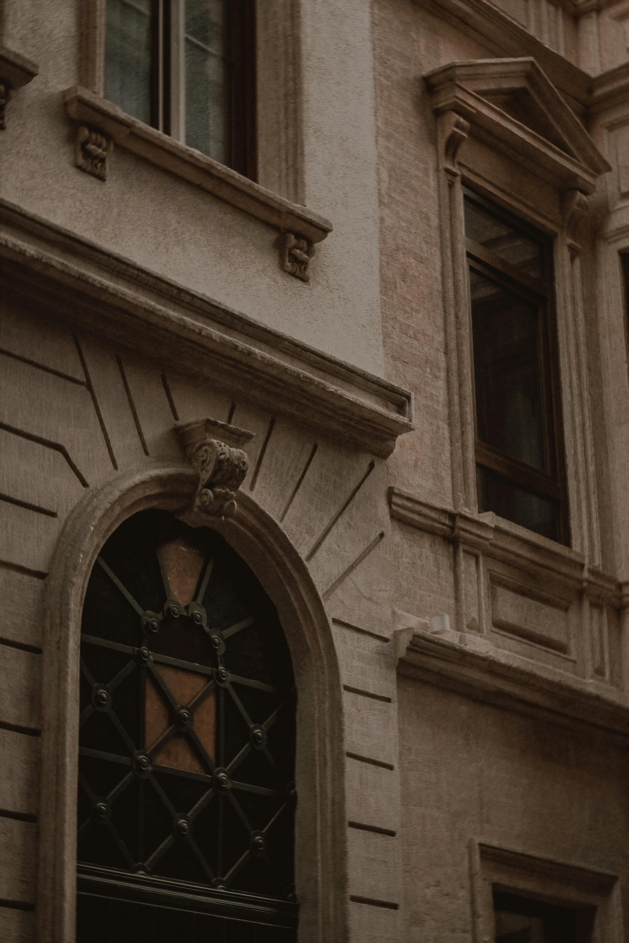 Capture of a classic building facade with detailed stonework and arched windows.