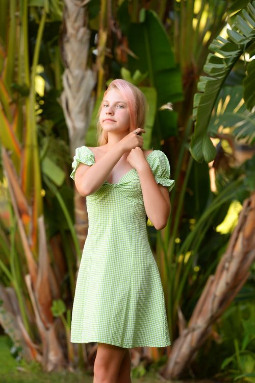 A Girl in a Dress Sitting on a Rock in Water · Free Stock Photo