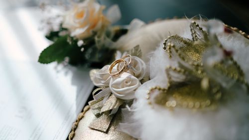 Free Close-up of gold wedding rings on decorative floral arrangement, symbolizing love and commitment. Stock Photo