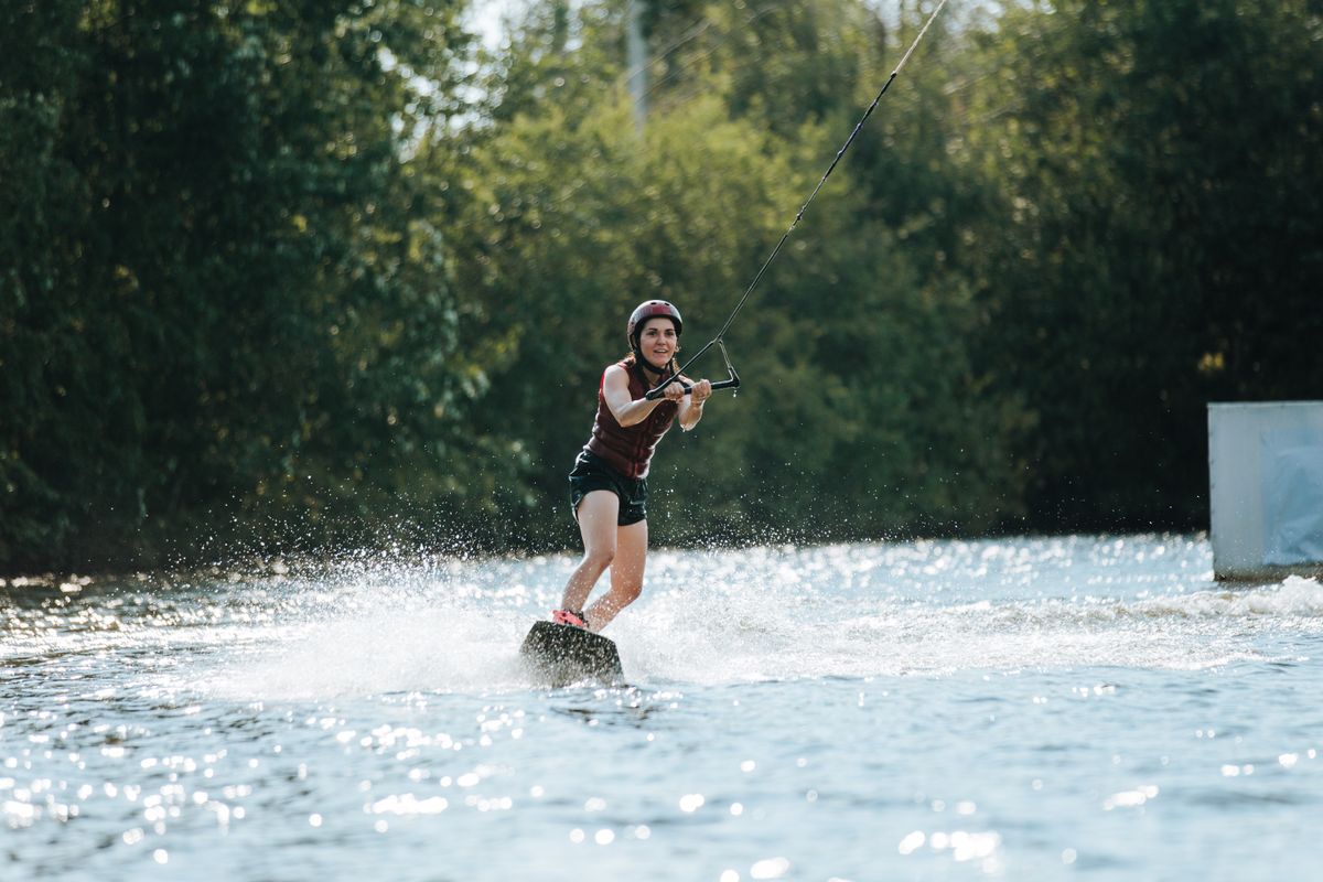 Wakeboarder riding across a sunny lake