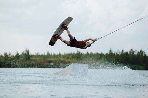 Free A thrilling action shot of a wakeboarder executing a mid-air trick over water. Stock Photo