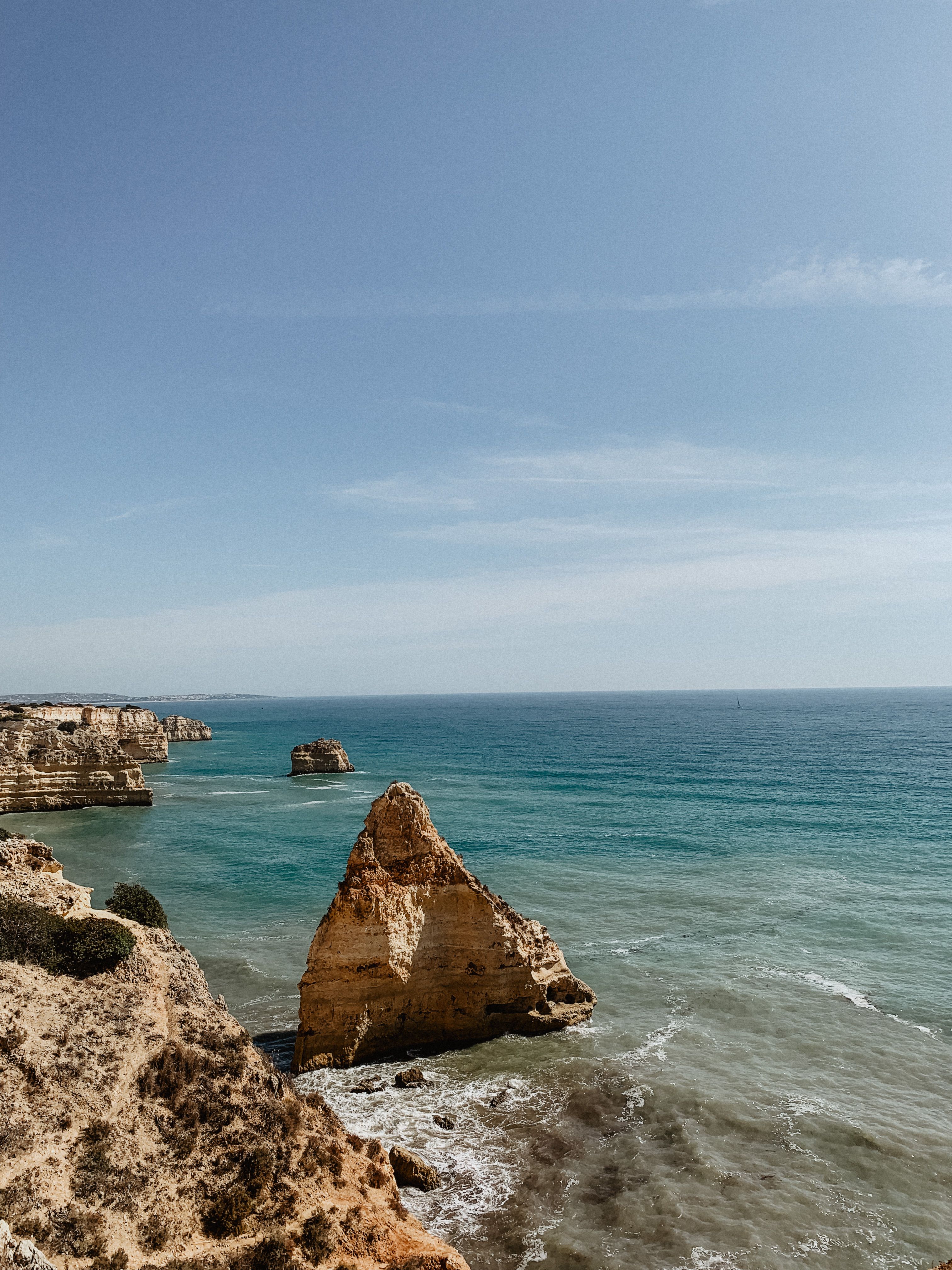 Majestic cliffs and serene blue waters define the Algarve coast, Portugal.