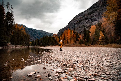 Woman Beside River in Mountains 