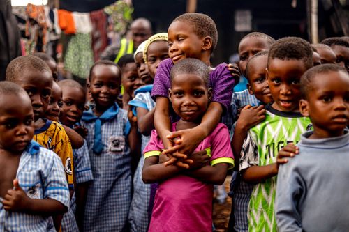 Free A heartwarming group of children smiling and embracing each other outdoors, showcasing joy and community. Stock Photo