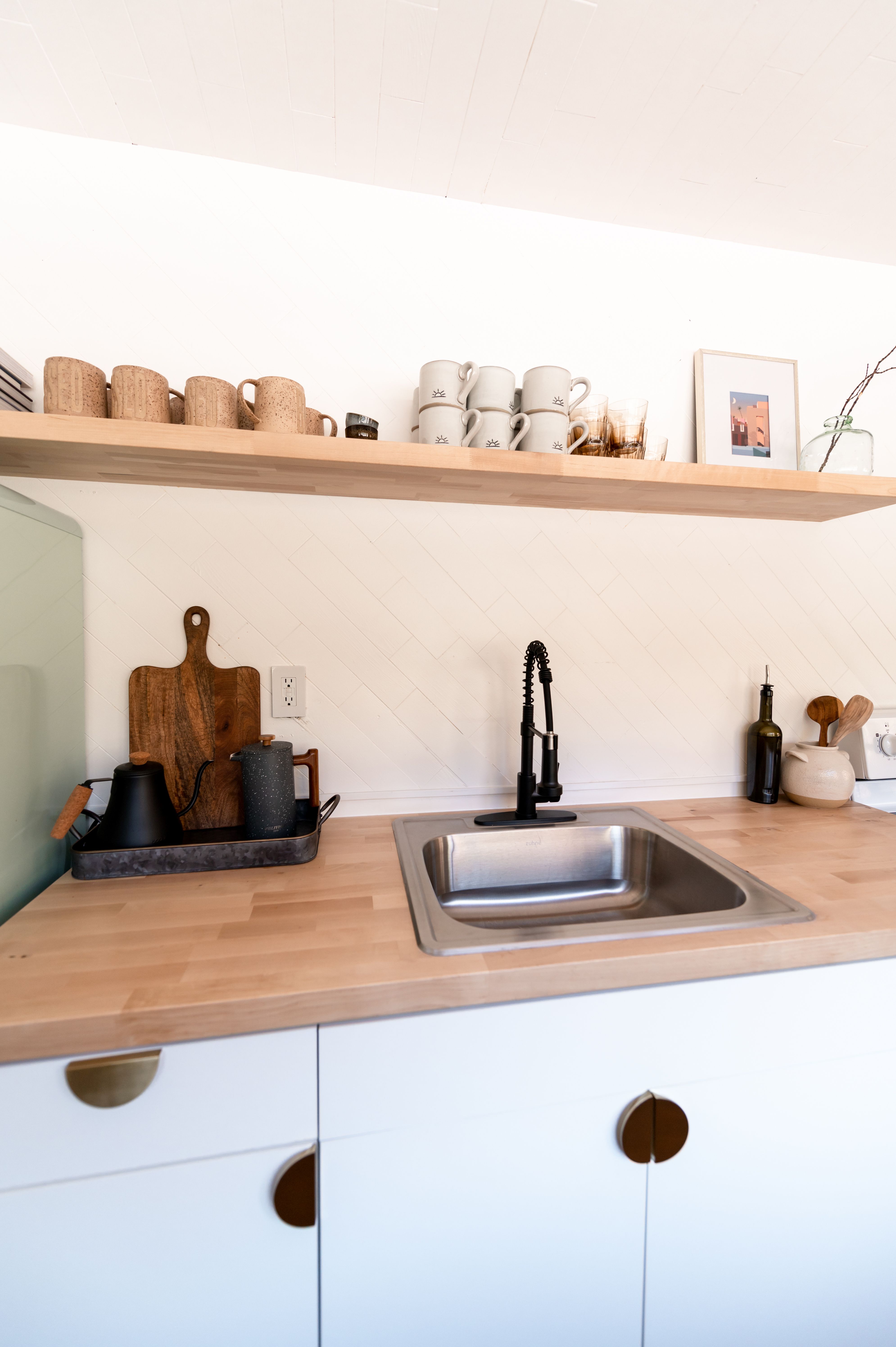 Stylish kitchen interior design featuring sleek cabinets, open shelves, and wooden accents.
