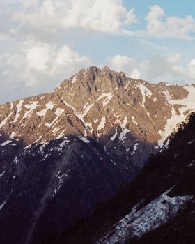 Dramatic view of a snowcapped mountain range under a clear blue sky.