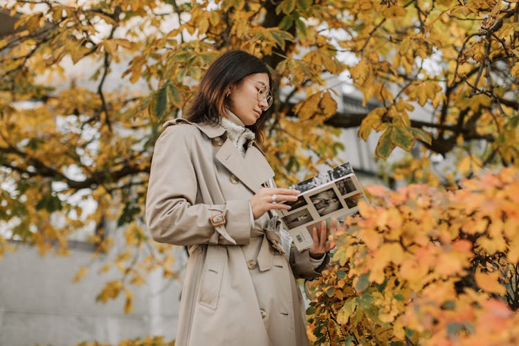 A Woman Reading A Book Under A Tree