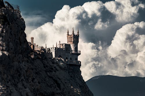 White and Black Concrete Castle on Top of Mountain