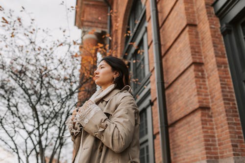 Woman Wearing a Brown Trench Coat Looking Afar