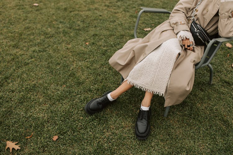 Person Sitting In Gray Metal Chair On Lawn Green Grass