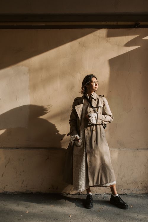 Woman Wearing Trench Coat Walking Near a Wall · Free Stock Photo