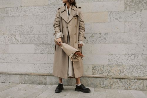 Woman Wearing Trench Coat Walking Near a Wall · Free Stock Photo