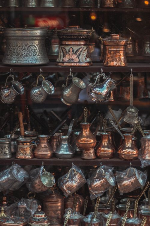 Free A collection of intricately crafted vintage bronze and copper utensils exhibited in a market setting. Stock Photo