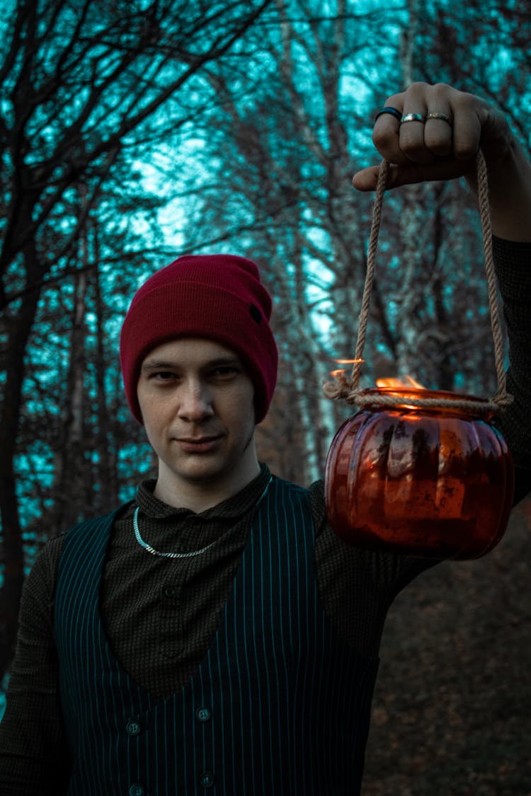 A Man In Red Beanie Holding A Lantern