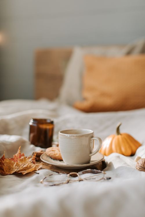 Free Warm autumn vibes with coffee and decor on a cozy bed for seasonal comfort. Stock Photo