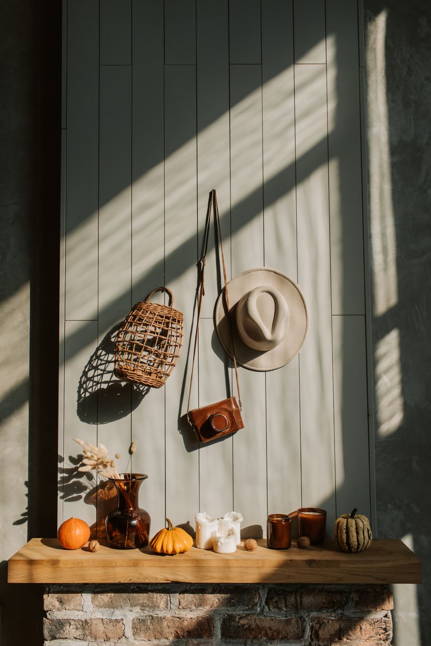 Cozy autumn scene featuring rustic decor, pumpkins, candles, and shadow play on wood planks.