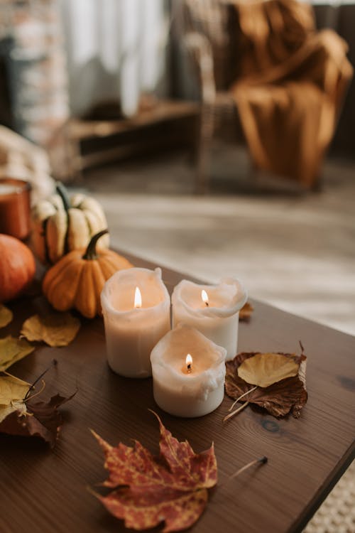 Free Lit Candles and Dried Leaves on the Table Stock Photo