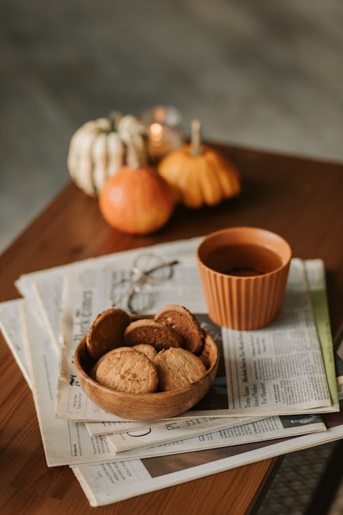 Free Cup of Tea and Bowl of Cookies on the Newspapers Stock Photo