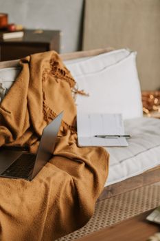 Comfortable setting with a laptop and planner on a sofa, perfect for a home office vibe.