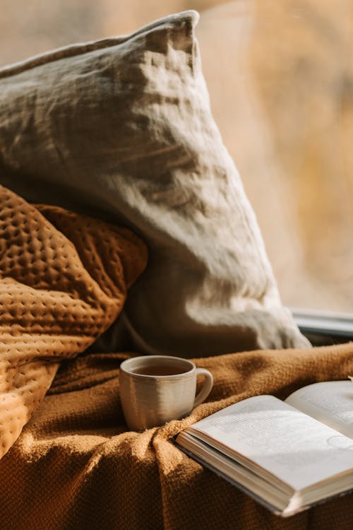 Free A Mug Cup Near a Book Stock Photo